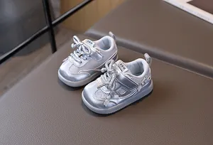 Detail view of silver baby sneakers with breathable mesh, soft soles, and bow accents