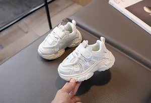 Gros plan détaillé de baskets blanches pour enfants avec velcro sur une surface texturée