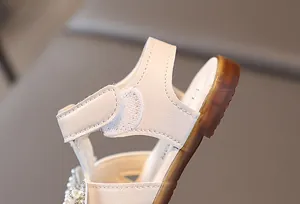 Close-up of toddler girls sandals featuring velcro strap and pearl floral decoration