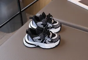 Close-up of kids' mesh chunky sneakers featuring black, white, and grey paneling with velcro