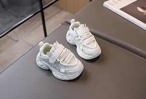 Gros plan de baskets blanches respirantes pour enfants avec scratch et semelle en gomme