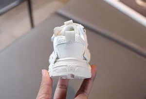 Gros plan sur la maille respirante blanche et la semelle épaisse des baskets pour enfants