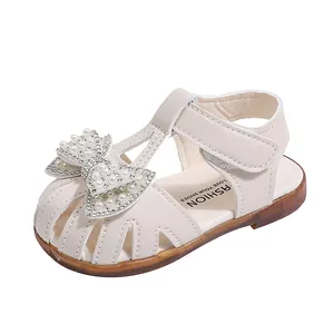 Elegant cream white toddler girl sandals with a pearl rhinestone bow and soft rubber sole