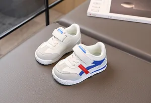 Dettaglio di sneaker per bambini con chiusure a strappo e strisce laterali rosso blu