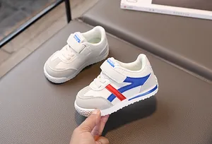 Dettaglio di sneakers per bambini con strisce rosse e blu e chiusura in velcro