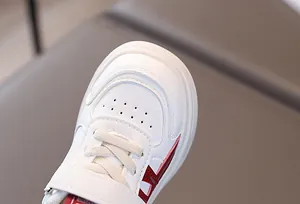 Close-up of toddler white sneakers featuring red stripes and breathable toe details