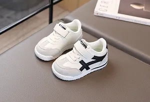 Dettaglio scarpe sportive bimbi con inserti in camoscio grigio e chiusura a strappo