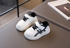 Detail of kids white leather sneakers with black velcro straps and breathable toe holes