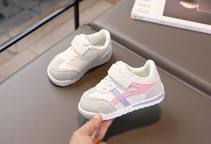 Dettaglio macro di scarpe da ginnastica per bimbi con velcro e strisce rosa pastello