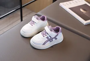 Detail of white and purple kids sneakers with velcro straps and anti-slip sole