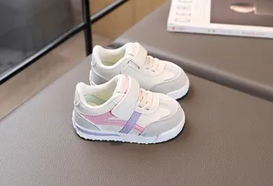 Dettaglio di sneakers per bambini con patchwork rosa e viola su sfondo grigio