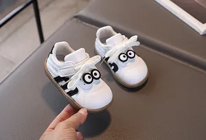 Detail eines Kleinkind-Sneakers mit süßem Cartoon-Augen-Patch und weißem Leder-Struktur