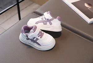 Detail view of white and purple kids sneakers with velcro straps and thick cushioned soles