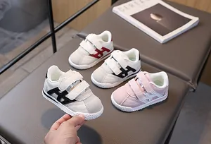 Detail view of toddler sneakers with dual hook-and-loop straps and rubber toe cap
