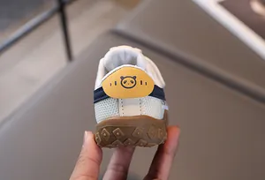 Dettaglio di scarpe per bambini con suole antiscivolo e toppe a forma di panda sul tallone