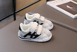 Detail of kids sneakers with double velcro straps and anti-slip rubber outsole texture