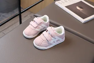 Detailed close-up of pink leather kids sneakers with double hook-and-loop velcro straps