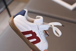 Detail von Baby-Sneakern mit rotem M-Patch und rutschfester Gummisohle in Makro