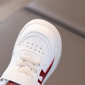 Kids white casual sneakers with breathable leather upper and red stripe details