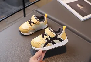 Detalle del zapato de bebé con malla transpirable y diseño lateral en forma de H marrón