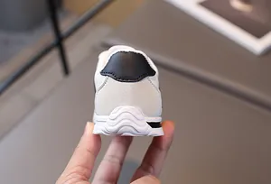 Close-up of the black leather heel patch and non-slip rubber sole of children's sneakers