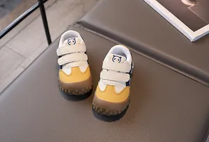 Vista dall'alto di sneakers per bambini con doppio velcro in giallo, bianco e blu navy