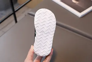 Detail of white anti-slip wave pattern outsole on children sports shoe with size 22 mark