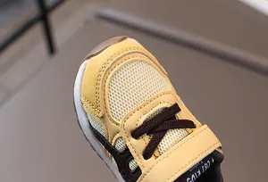 Primer plano de la malla transpirable y el cierre de velcro en zapatos amarillos de bebé