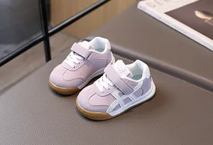 Détail de basket enfant violette et blanche avec fermeture scratch et semelle en gomme