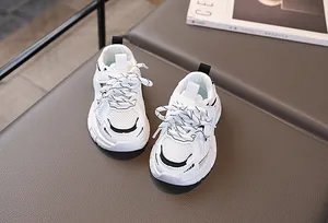 Gros plan de baskets blanches pour enfants en maille respirante avec lacets tressés