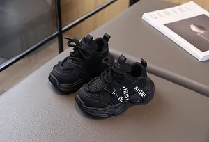 Détail de baskets noires pour enfants avec panneaux en maille et logo RIGEI sur le côté