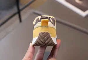 Primer plano de zapatillas de bebé con suela de goma y tirador amarillo en el talón