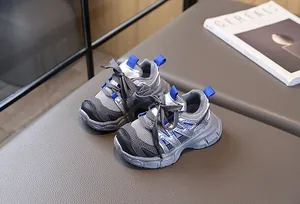 Détail de baskets respirantes en mesh gris et cuir argenté pour enfants avec touches bleues