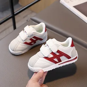 Classic white children sneakers with red logo and dual velcro straps for kids