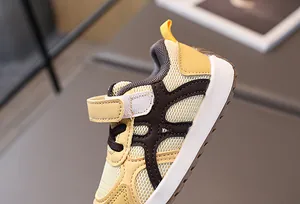 Detalle de zapatillas de malla para bebé con velcro y parte superior de tela amarilla