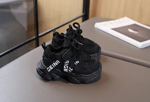 Détail de baskets noires pour enfants avec mesh respirant, semelle épaisse et bride velcro