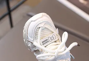 Detail eines weißen Mädchen-Sneakers mit atmungsaktivem Mesh und Fashion-Etikett