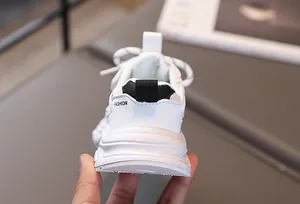Gros plan du talon de basket enfant blanche avec languette noire et maille filet
