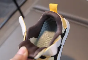 Detalle del interior del zapato para bebé con suela azul suave y forro de tela marrón