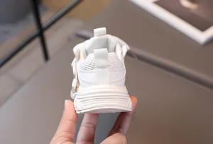 Detail eines weißen Kleinkind-Sneakers mit atmungsaktivem Mesh und Klettverschluss