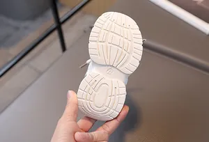 Detail der weißen Kleinkind-Sneakersohle mit rutschfesten Rillen und Gravur der Größe 22