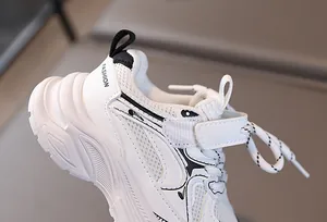 Gros plan sur baskets blanches pour enfants avec maille respirante et fermeture velcro