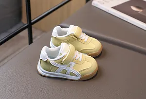 Gros plan de baskets enfant jaunes et blanches avec scratch et semelle en caoutchouc