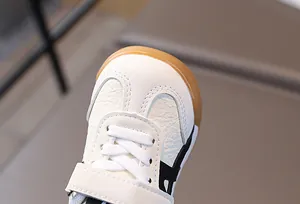 Gros plan de baskets enfant en cuir blanc avec velcro et embout en caoutchouc durable