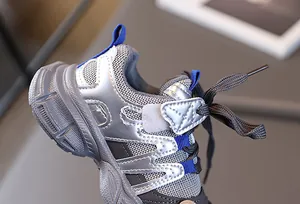 Détail de baskets enfants avec cuir argenté et tige en mesh respirant de qualité