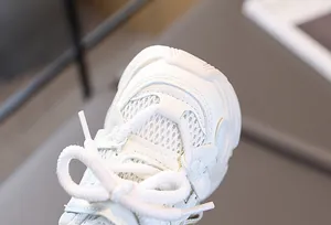 Gros plan détaillé des baskets blanches pour enfants avec mesh respirant et couture