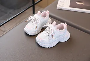 Détail de baskets enfant roses et blanches avec scratch sur une surface texturée élégante