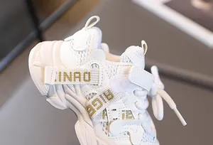Détail du tissu en maille blanche et du velcro sur la basket de sport pour enfant