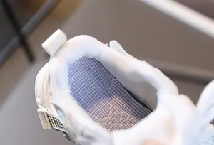 Gros plan sur la semelle intérieure en maille bleue respirante et le col des baskets enfant