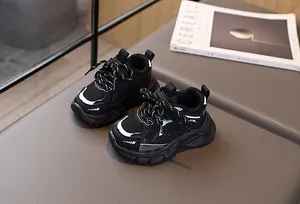 Détail de baskets pour enfants en maille avec design patchwork en cuir noir et blanc